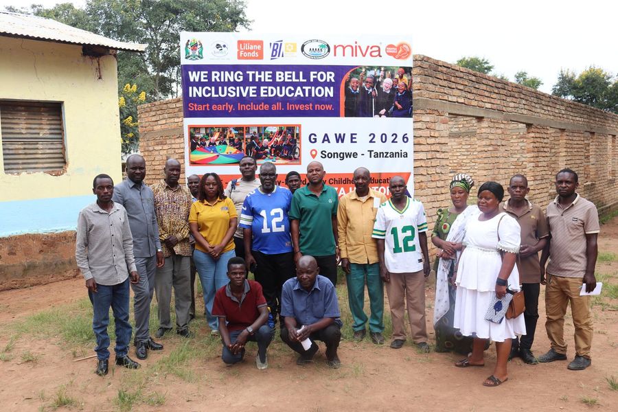 Community members and BIT staff in front of the We Ring the Bell for Inclusive Education banner, GAWE 2026